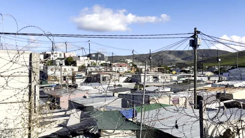 Congested township tin houses on other side of barbed wire in South Africa Stock Footage 331229732