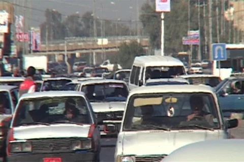 Congested traffic approaches camera in Mosul, Iraq street. Pedestrians cross Stock Footage 86753142