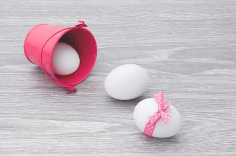 Congratulations on Easter. Eggs scattered on the table with a pink bucket. Foto stock