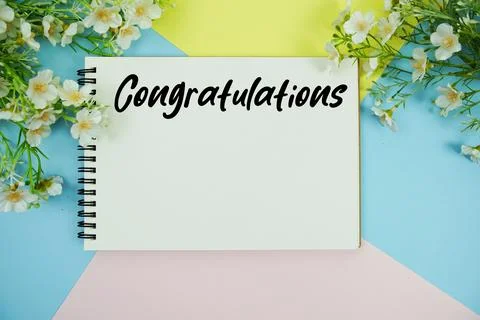 Congratulations text written on notepad with flowers decorations flat lay o.. Stock Photos