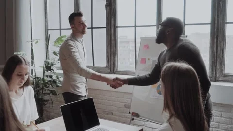 Congratulations with your promotion! two men, black and white guy shaking hands Video stock 132603412
