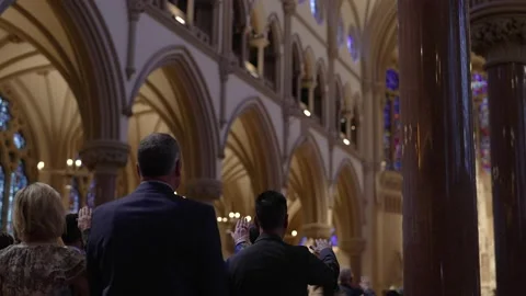 Congregation praying inside of a catholic church during mass. Vídeo Stock 237356730