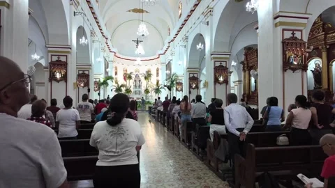 Congregation standing during daytime mass service inside historic San Pedro Stock Footage 336556410