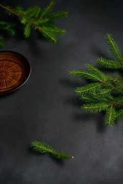 Coniferous branches on dark background top view. Empty Clay Old Plate in corn Stock Photos