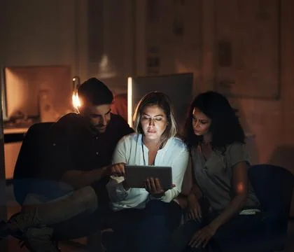 Connect to productivity. a group of colleagues using a digital tablet together Stock Photos