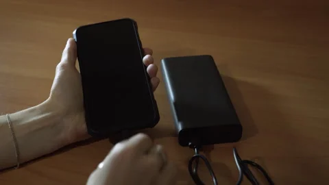 Connect the USB cable to an external battery for fast charging of the smartphone Stock-Footage 256240083