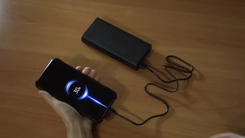 Connect the USB cable to an external battery for fast charging of the smartphone Stock Footage 256240103