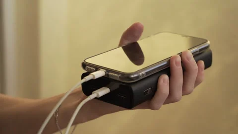 Connect the USB cable to an external Power Bank battery to charge smartphone Stock-Footage 256056342