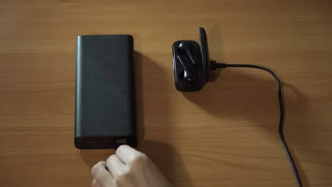 Connect the USB cable to an external Power Bank battery to charge the headphones Stock-Footage 256056349