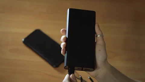 Connect the USB cable to an external Power Bank battery to charge smartphone Stock-Footage 256056382