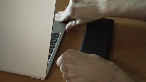 Connect the USB cable to an external Power Bank battery to charge the laptop Stock Footage 256070865