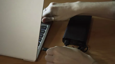 Connect the USB cable to an external Power Bank battery to charge the laptop. Stock-Footage 256070919