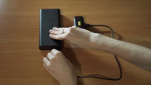 Connect the USB cable to an external Power Bank battery to charge the headphones Stock Footage 258336610