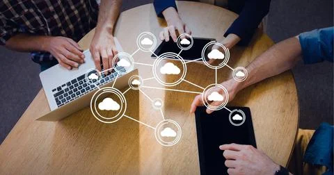 Connected network of bubbles with cloud icons over businessmen at table with 스톡 사진