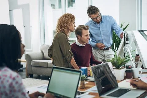 The connected team is an efficient team. a group of colleagues using a computer Stock Photos