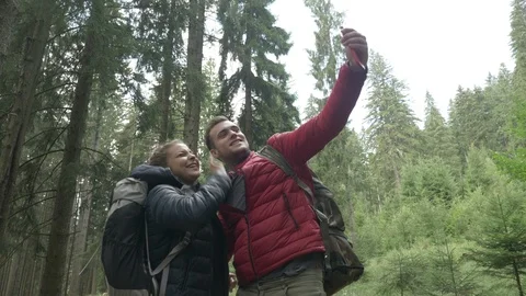 Connected by technology young couple of hikers using smartphone for video cal Stock Footage 86219923