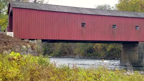 Connecticut’s scenic red Covered Bridge at New England changing autumn leaves Stock Footage 166175530