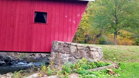 Connecticut’s scenic red Covered Bridge at New England changing autumn leaves Stock Footage 166175973