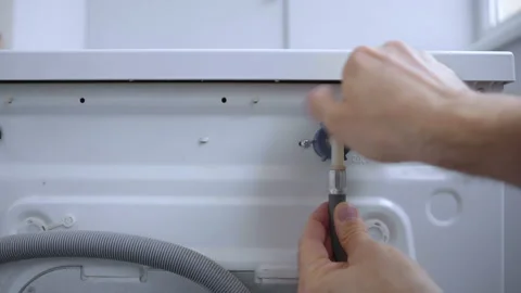 Connecting and installing cold water supply hose to back of the washing machine Stock Footage 158756475