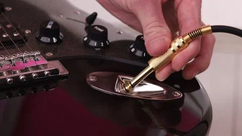 Connecting audio cable to electric guitar Stock Footage 265238217
