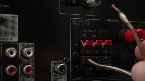 Connecting Bare Wires to Surround and Center Outputs on AV Receiver Stock Footage 337910933