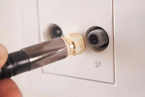 Connecting a cable to a wall socket for a device Stock Photos