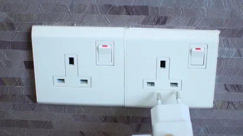 Connecting the charger to a foreign outlet through an adapter Video stock 124879155
