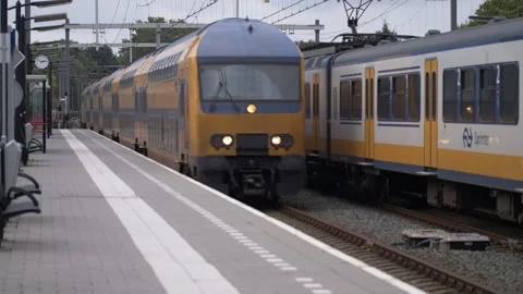 Connecting Cities: Dutch Intercity Train Speeds Past Station Video stock 240953279