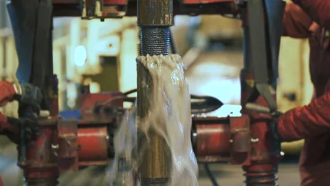 Connecting of drill pipes on the drilling platform. Water flows up from the well Vidéo 139839926