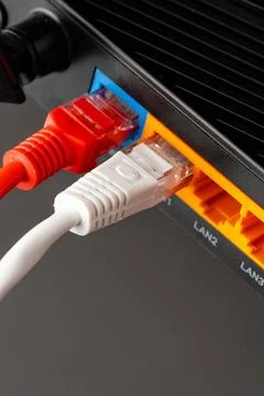 Connecting ethernet cables to a network router in a home office setup Stock Photos