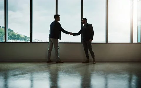 Connecting with an influential client. two young businessmen shaking hands in a Fotos Stock