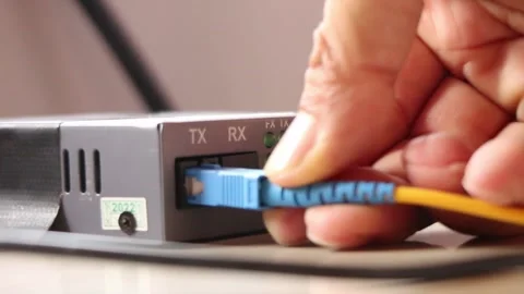 Connecting the internet network by plugging in the fiber optic cable connector Stock Footage 291595527