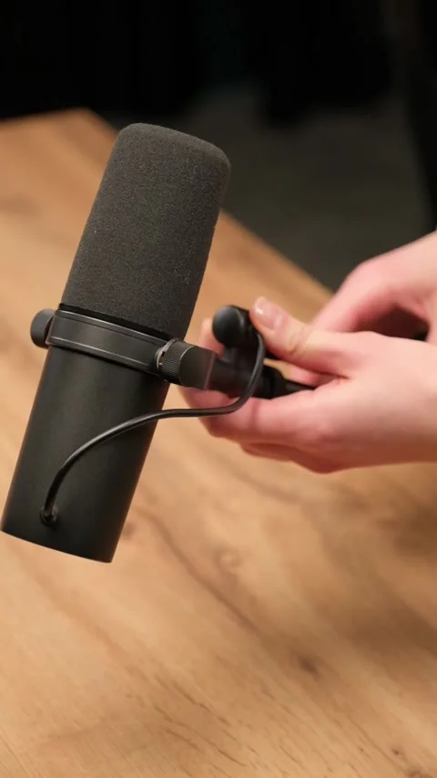 Connecting microphone to cable on wooden table Stock Footage 306779832