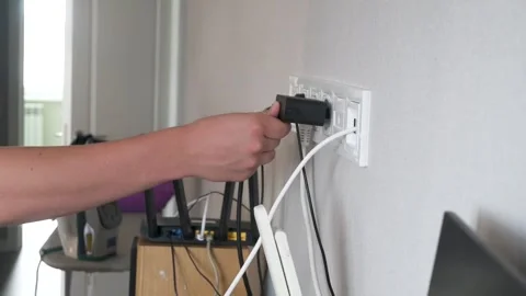 Connecting a power adapter to a wall socket Stock Footage 317296480