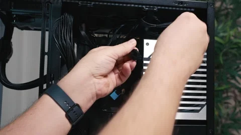 Connecting power cable to the power supply unit during PC build Stock Footage 325808920