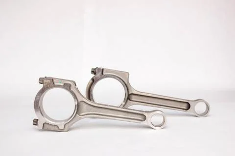 Connecting rod from a car engine isolated on white. Stock Photos