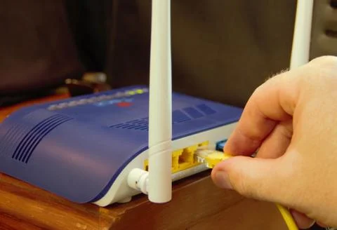 Connecting the router to the network cable by plugging in the cable to the ba Stock Photos