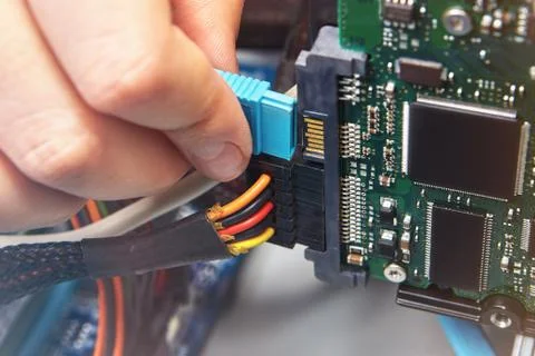 Connecting SATA data cable to HDD with motherboard. Stock Photos