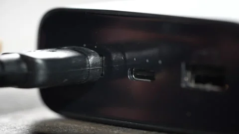 Connecting a usb cable to a black power bank. Portable autonomy charger Stock Footage 297506335