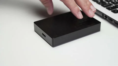 Connecting usb cable to a portable hard disk on white background Stock Footage 143866069