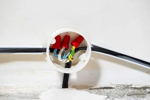 Connection of electrical wires in electrical boxes using red caps of connecting Fotos Stock