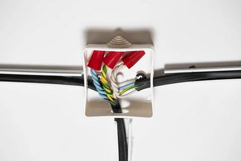 Connection of electrical wires in electrical boxes using red caps of connecting Foto stock