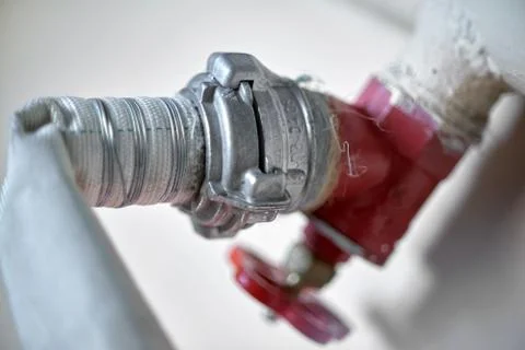 Connection of a fire hose with a red fire cock, close-up Foto stock