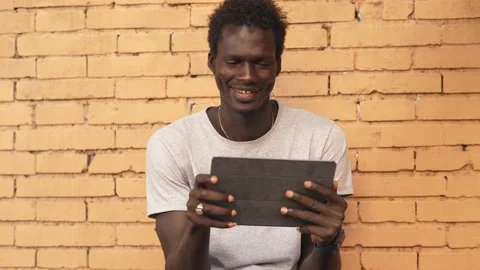 Connection, technology - confident african young man types on tablet Stock Footage 224301352