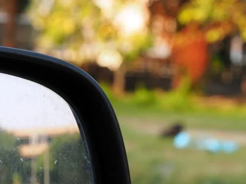Conner of dirty side mirror len of car on bad traffic road Stock Photos