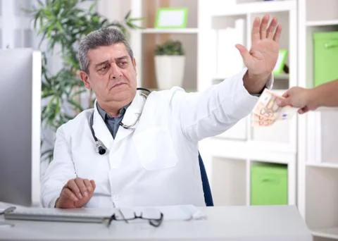 Conscience senior doctor refuses bribes from patients Stock Photos