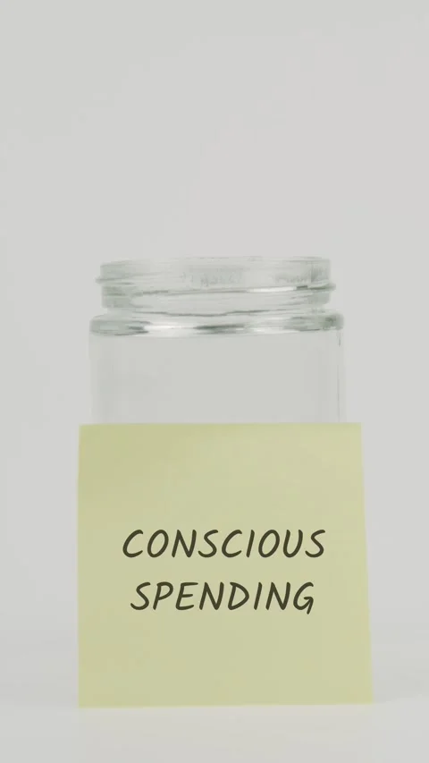 Conscious spending text or word on yellow sticky note attached to glass jar Stock Footage 311696535