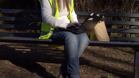 Conservation volunteer working on a park bench with laptop Stock Footage 151691908