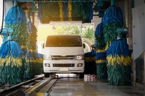Conservative automatic carwash machine in action with sunlight effect Stock Photos