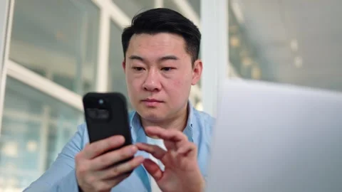 Conservative man using mobile phone while setting up portable computer for work Stock Footage 276422053